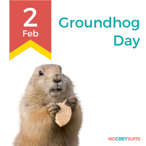 A graphic celebrating Groundhog Day on February 2nd, featuring a photograph of a groundhog in the foreground. The groundhog is facing forward and holding a heart-shaped cookie. The background is split into two parts: the top half is black, and the bottom half is teal. On the left side, there's a bold yellow ribbon design with the date '2 Feb' printed on it in red. On the right side, the words 'Groundhog Day' are written in white. The bottom right corner has the text 'NO GREY SUITS' in small white lettering.